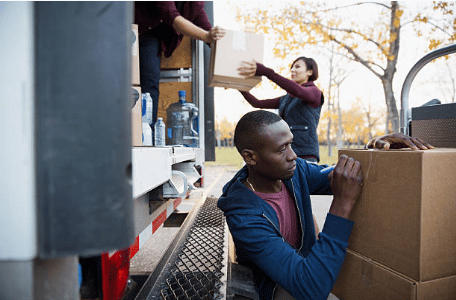 personnes mettant des cartons dans un camion pendant un déménagement