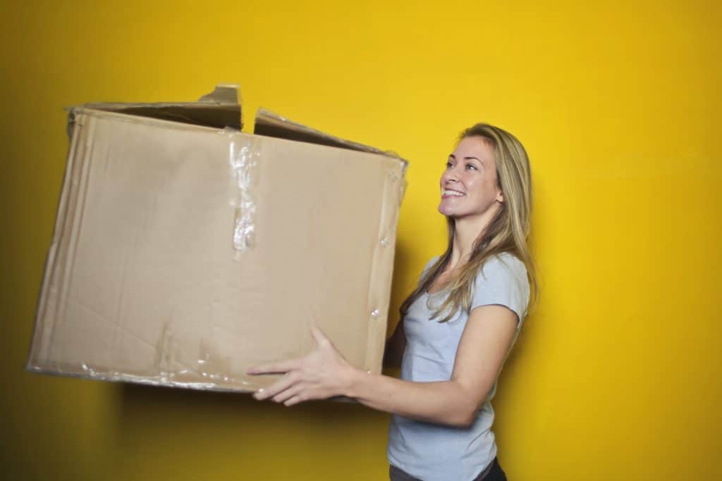 Une femme portant un carton de déménagement